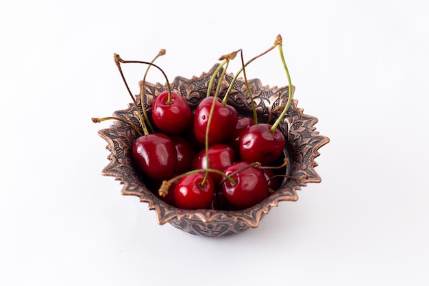 Vista frontal de las cerezas ácidas rojas dentro de la placa de jugo de fruta blanca suave