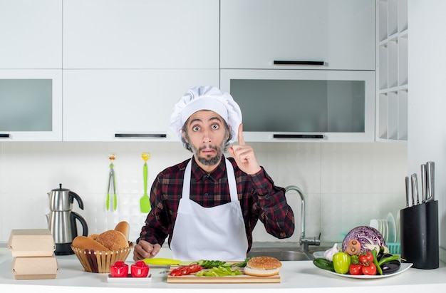 Vista frontal del chef masculino sorprende con una idea en la cocina