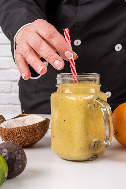 Foto gratuita vista frontal del chef poniendo paja en jugo de fruta