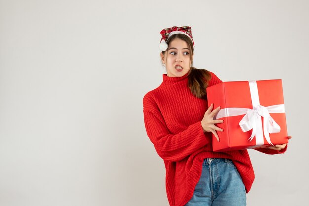 Vista frontal chica confundida con sombrero de santa con pie de regalo