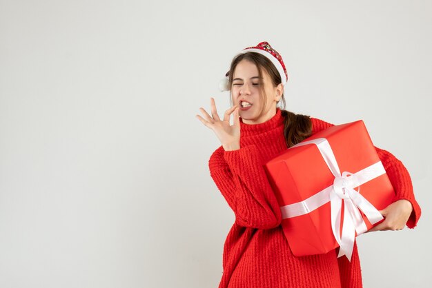 Vista frontal chica eufórica con gorro de Papá Noel haciendo sabroso gesto delicioso