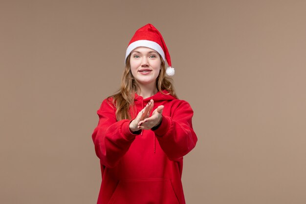 Vista frontal chica de Navidad con cara emocionada sobre fondo marrón mujer vacaciones Navidad