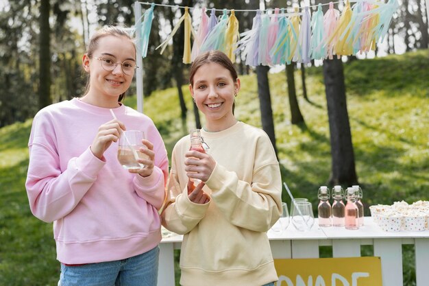 Vista frontal chicas sonrientes bebiendo limonada