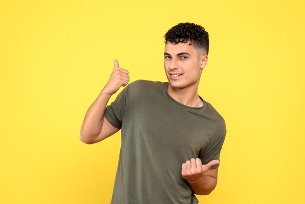 Vista frontal de un chico el chico está sonriendo y apunta a los lados con los pulgares