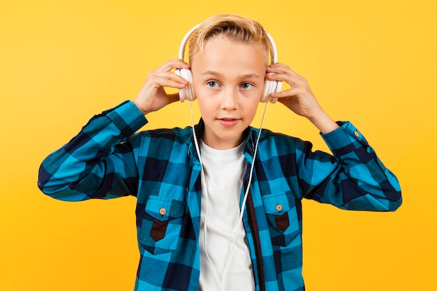 Foto gratuita vista frontal chico poniéndose los auriculares