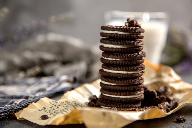 Una vista frontal choco cookies dulce y delicioso con un vaso de leche en el escritorio gris galleta galleta chocolate azúcar dulce