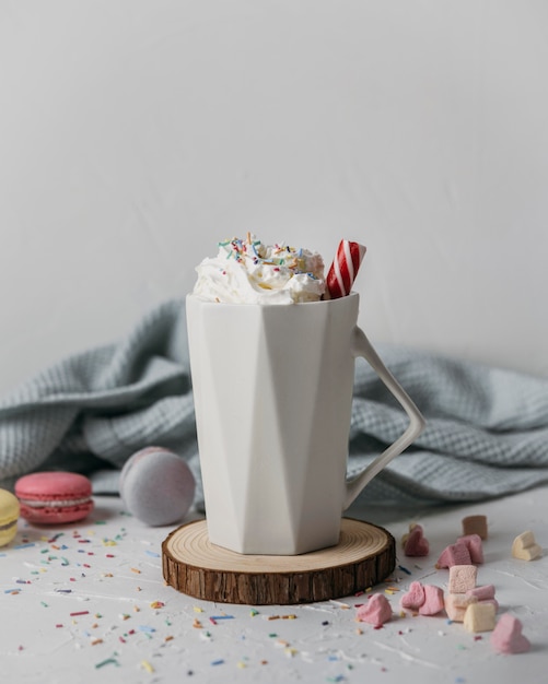 Vista frontal de chocolate caliente con crema batida en taza