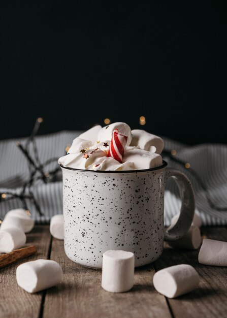 Vista frontal de chocolate caliente en taza con malvaviscos