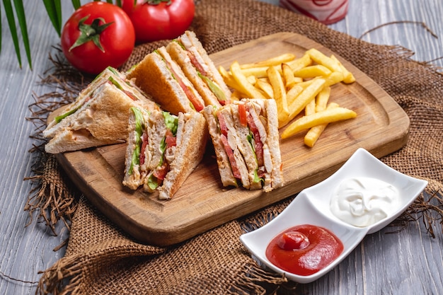 Vista frontal club sandwich con ketchup de papas fritas con mayonesa y tomates