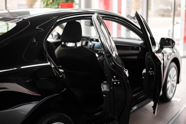 Vista frontal coche nuevo negro con puertas abiertas