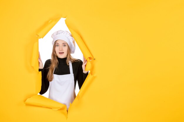 Vista frontal cocinera femenina en color amarillo sol foto cocina trabajo papel emoción comida