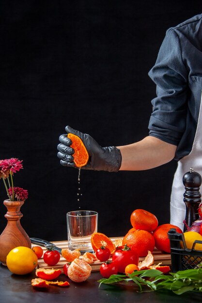 Vista frontal cocinera haciendo jugo de mandarina en gris ensalada de cocina comida saludable comida fruta trabajo dieta vegetal bebida fresca