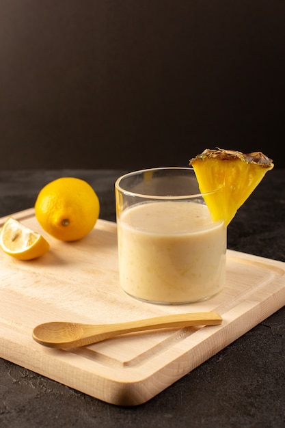 Una vista frontal cóctel fresco deliciosa bebida refrescante dentro de un vaso pequeño cerca del escritorio de crema de madera sobre el fondo oscuro beber jugo de verano