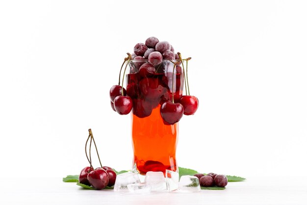 Vista frontal de un cóctel de frutas frescas con cerezas rojas frescas de enfriamiento con hielo en blanco, cóctel de jugo de bebida color de fruta