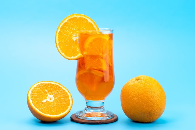 Una vista frontal de cóctel de frutas frescas con rodajas de frutas frescas enfriamiento con hielo en azul, cóctel de jugo de bebida color de fruta