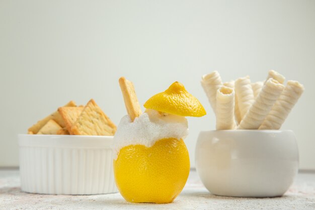 Vista frontal de cóctel de limón con hielo en el jugo de cóctel de cítricos de mesa blanca