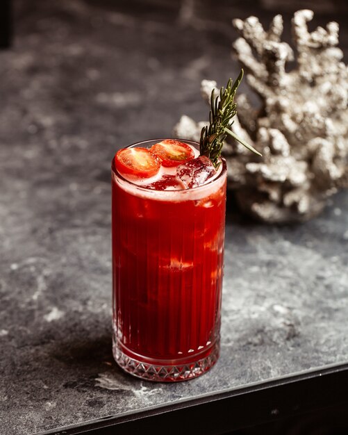 Una vista frontal de cóctel rojo fresco frío y sabroso dentro del vidrio sobre la superficie oscura con jugo de bebida de fruta