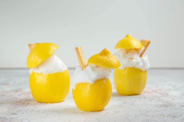 Vista frontal de cócteles de limón con hielo en la mesa blanca cóctel de jugo de bebida cítrica