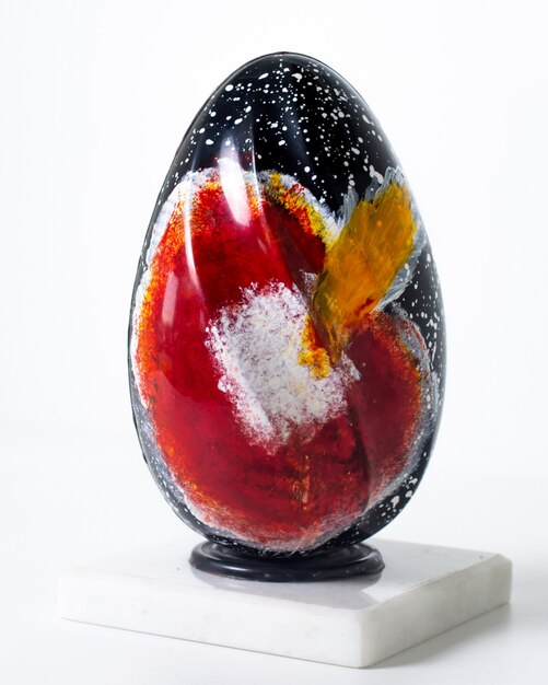 Vista frontal de color huevo negro y rojo sobre la superficie blanca