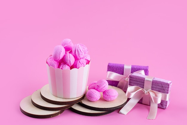 Una vista frontal de color rosa, galletas deliciosas y deliciosas junto con cajas de regalo de color púrpura en rosa, galleta de galleta de azúcar dulce