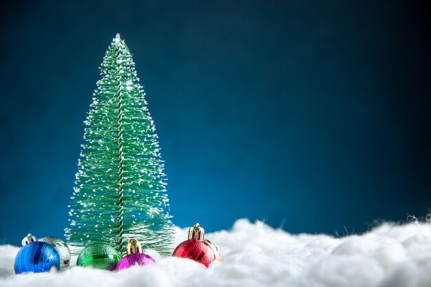 Vista frontal colorido árbol de navidad pequeño árbol de navidad juguetes