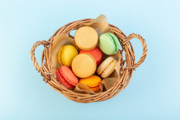 Una vista frontal de coloridos macarons franceses dentro de la canasta hornear