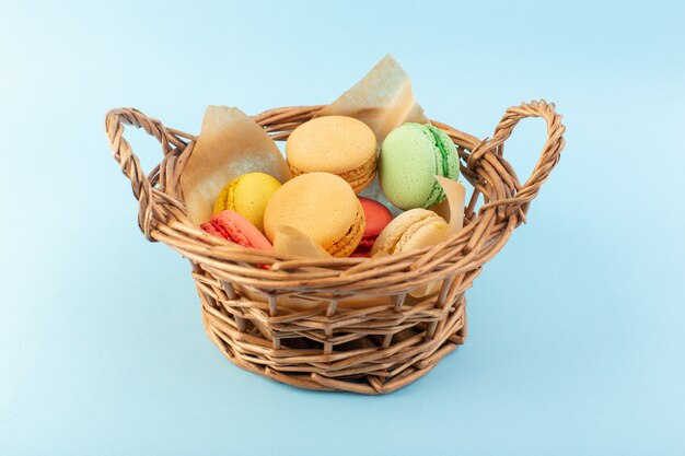 Una vista frontal de coloridos macarons franceses dentro de la canasta hornear