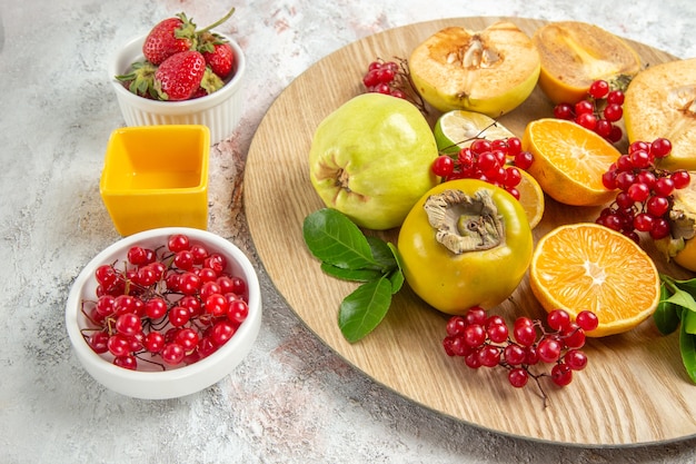 Vista frontal de la composición de la fruta frutas frescas en la mesa blanca frutas frescas de color maduro