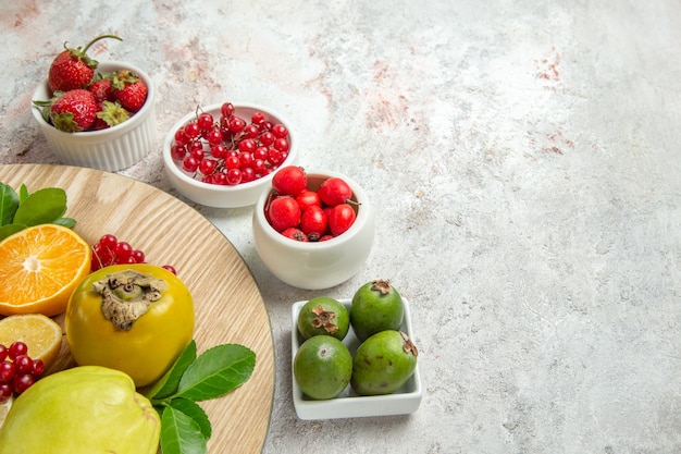 Vista frontal de la composición de frutas diferentes frutas en mesa blanca baya fruta fresca madura