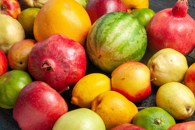 Vista frontal de la composición de frutas frescas manzanas, peras y mandarinas en el escritorio de color azul oscuro de frutas maduras de color de árboles frescos muchos suaves