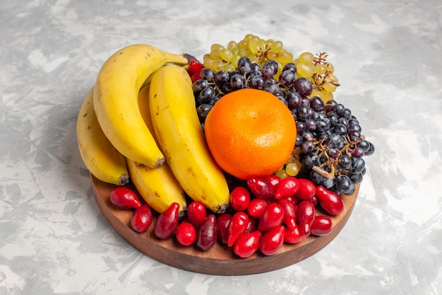 Vista frontal composición de frutas plátanos cornejos y uvas en superficie blanca fruta berry composición de frescura vitamina color