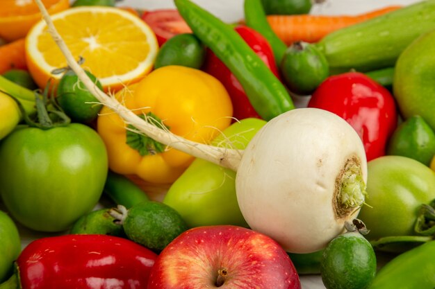 Vista frontal composición vegetal con frutas sobre fondo blanco dieta ensalada salud color maduro