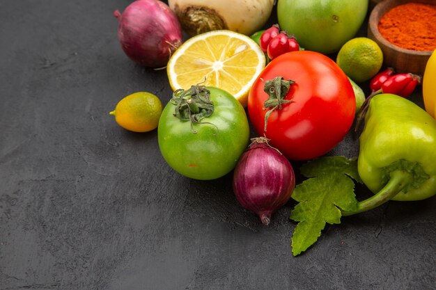 Vista frontal de la composición de vegetales frescos con condimentos en la superficie oscura comida de dieta de color ensalada de comida de vida saludable