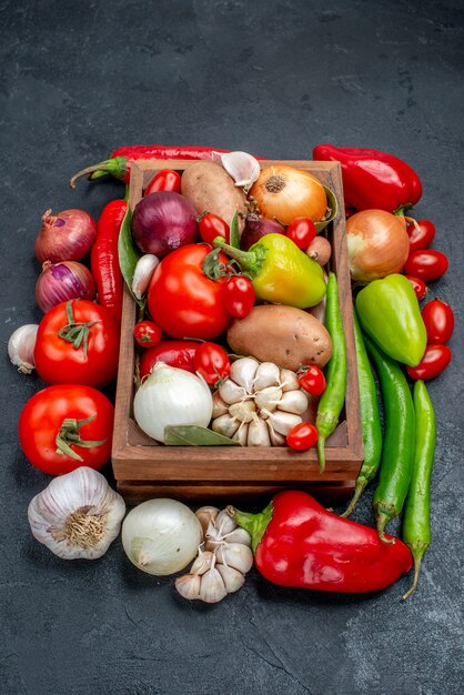 Vista frontal de la composición de verduras frescas en ensalada de mesa gris color maduro fresco