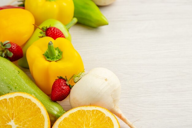 Vista frontal de la composición de verduras frescas con frutas sobre fondo blanco color de comida ensalada madura fruta madura espacio libre