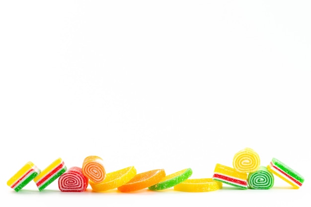 Una vista frontal confites de colores pegajosos y dulces aislados en blanco, dulce color de confitería de azúcar