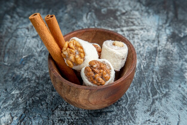 Vista frontal de confituras de nueces con canela sobre superficie oscura