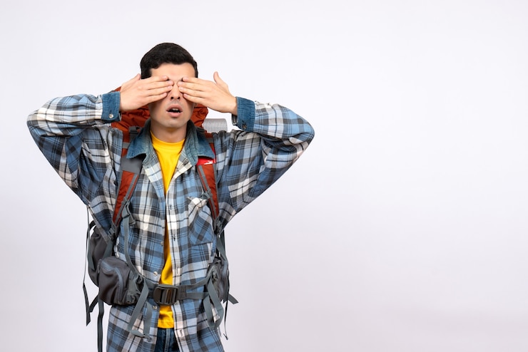 Foto gratuito vista frontal confundido hombre viajero con mochila cubriéndose los ojos con las manos