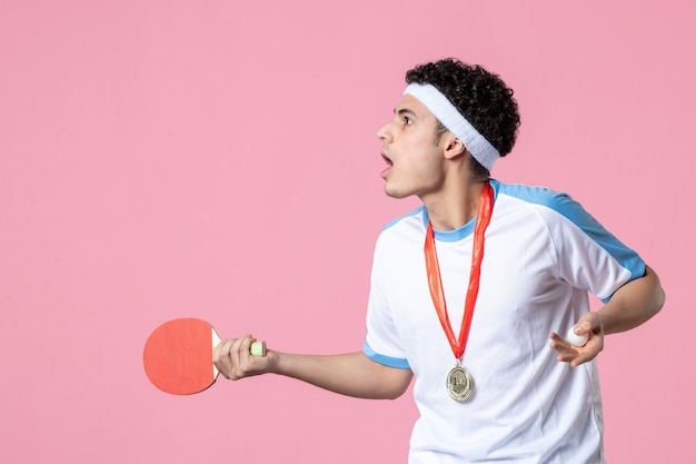 Vista frontal confundido jugador masculino con poca raqueta y medalla