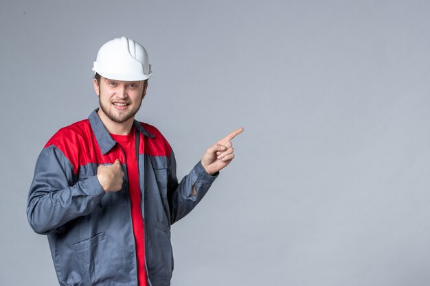 Vista frontal del constructor masculino en uniforme sobre fondo claro