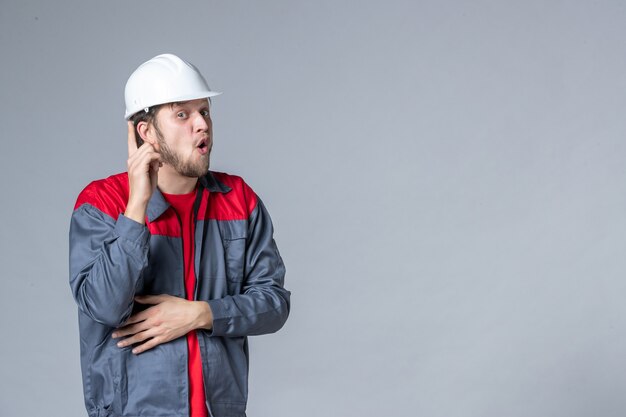 Vista frontal del constructor masculino en uniforme sobre fondo claro