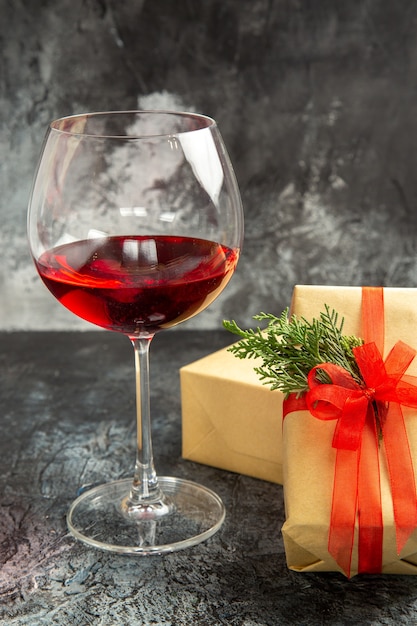 Vista frontal de la copa de vino regalos de Navidad sobre fondo oscuro