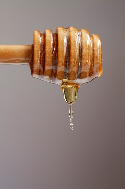 Vista frontal del cucharón de miel de madera con miel
