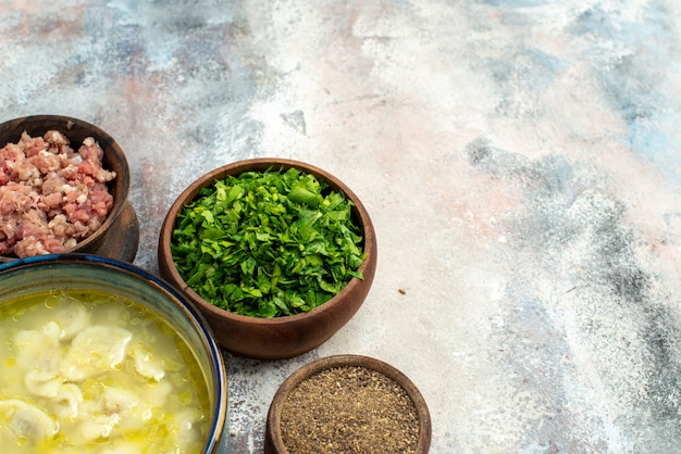 Vista frontal cuencos de sopa de bolas de masa hervida dushbara con carne verde pimienta sobre fondo desnudo espacio libre