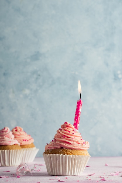Vista frontal de cupcake de cumpleaños con espacio de copia y vela encendida