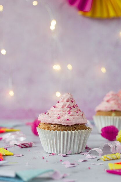Vista frontal de cupcake de cumpleaños con glaseado y chispitas