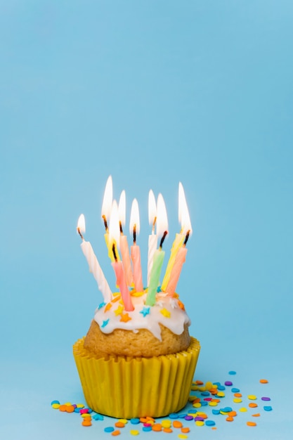 Vista frontal cupcake con velas encendidas y espacio de copia
