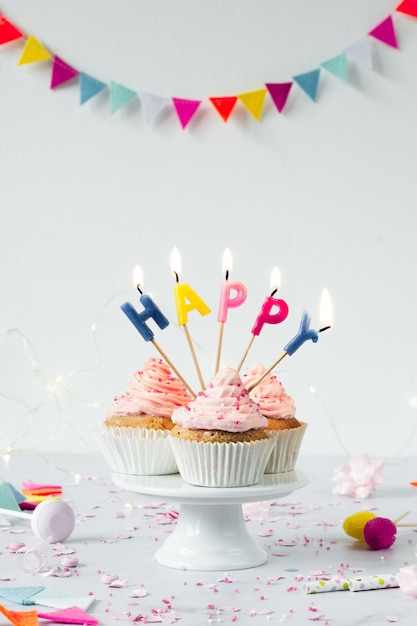 Vista frontal de cupcakes de cumpleaños con velas encendidas
