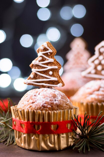 Vista frontal de cupcakes navideños con cobertura de árbol de pan de jengibre