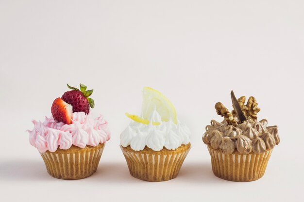 Foto gratuita vista frontal cupcakes ricos de diferentes sabores